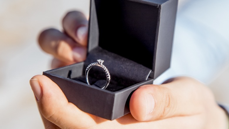 Hands holding open box with ring