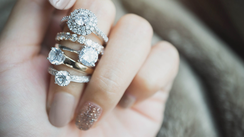 Finger displaying several diamond rings