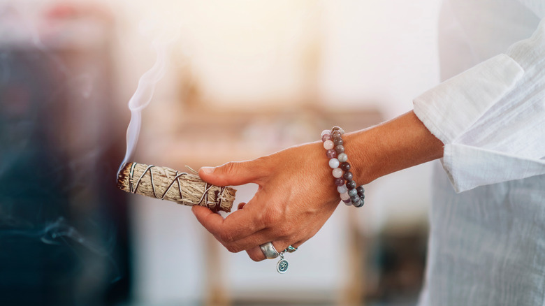 woman holding sage smudge stick