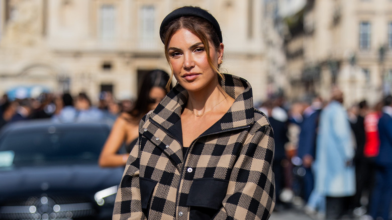 Woman wearing black headband, checked jacket