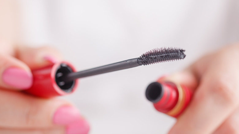 woman holding mascara wand 