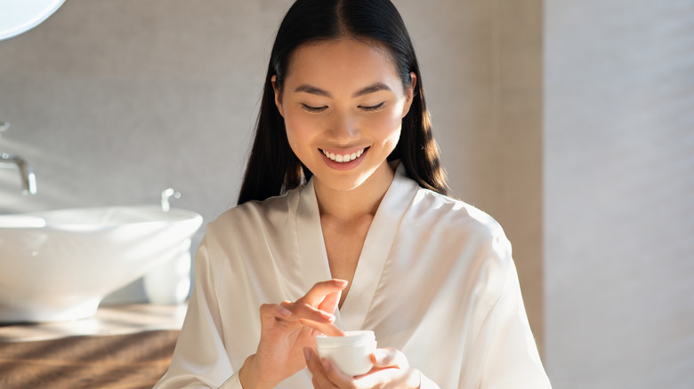 Woman holding face cream pot