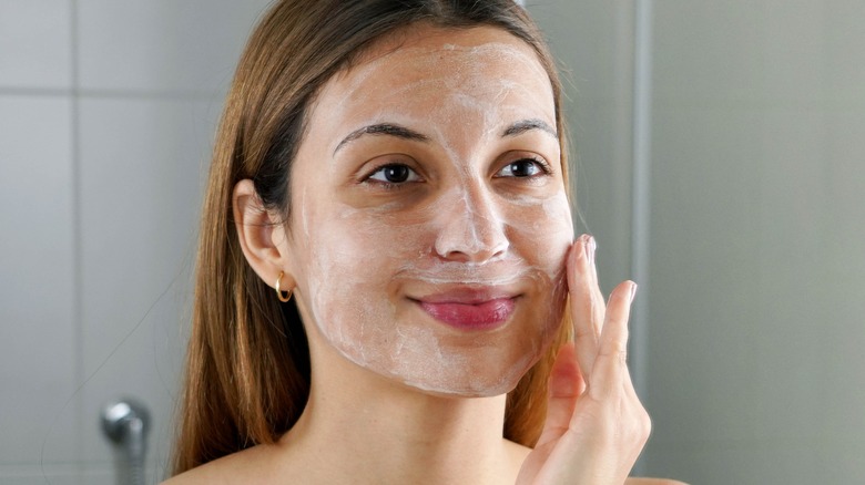 girl peeling her skin with exfoliant gel