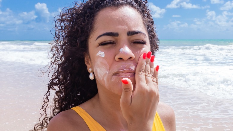 female applying sunscreen at the beach