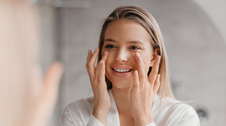 Woman applying moisturizer