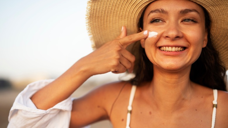 Woman applying sunscreen on beach