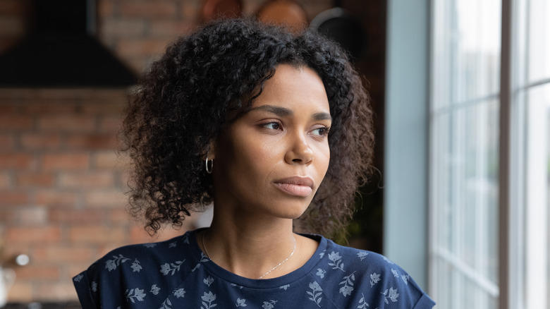 Woman looking pensively out a window