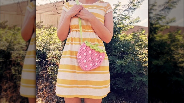 Woman models crocheted strawberry purse