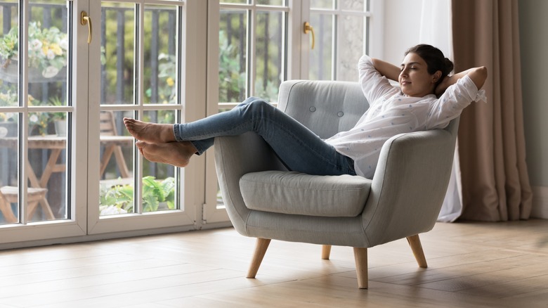 Woman relaxes in living room chair with eyes closed