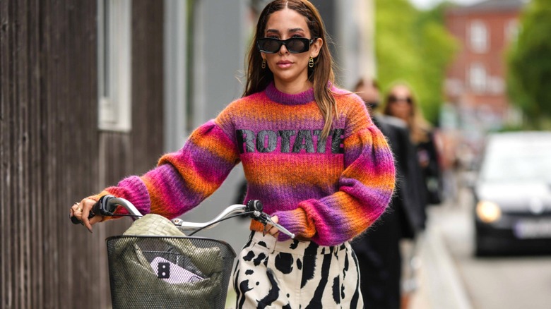 Woman wearing rainbow sweater and graphic trousers