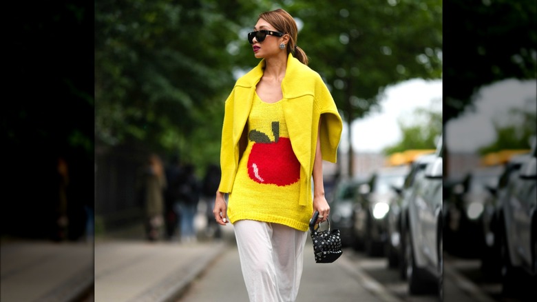 Woman wearing yellow apple sweater