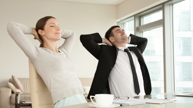 Two employees stretching backs like in cat-cow