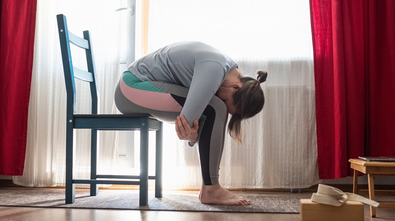 Woman doing forward bend in chair