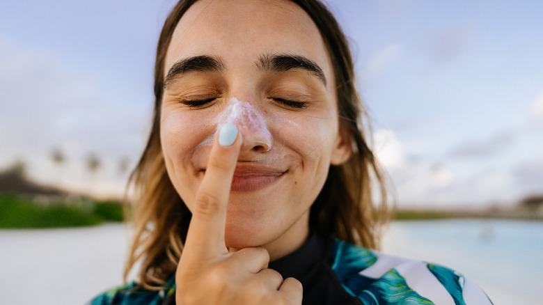 Woman putting SPF on nose
