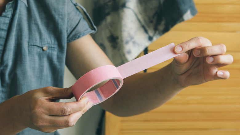 woman holding pink scotch tape 