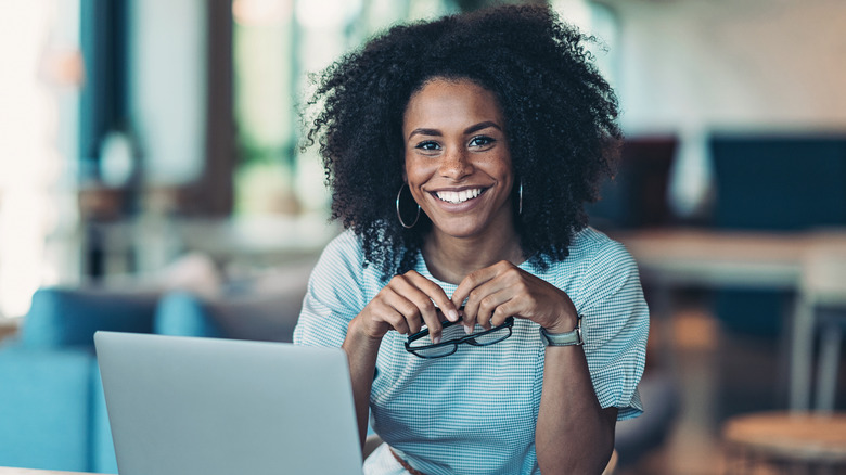 Woman smiling and holding glasses