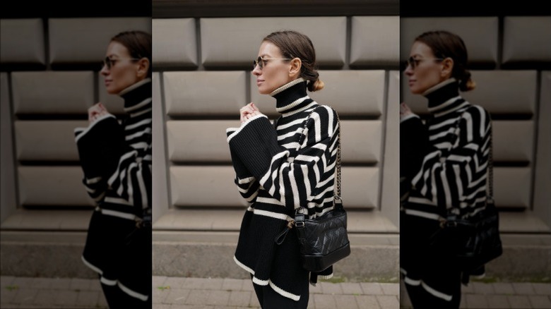 Individual in a striped turtleneck bell-sleeved sweater