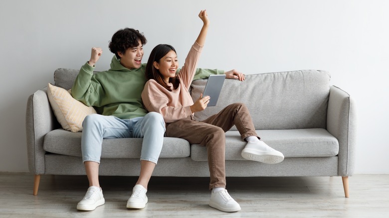 Happy couple looking at laptop