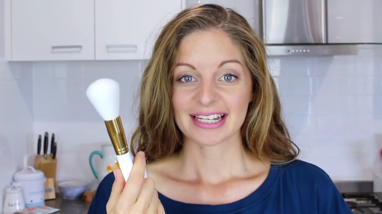 woman holding a powder brush 