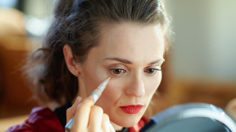 Woman applying liquid concealer