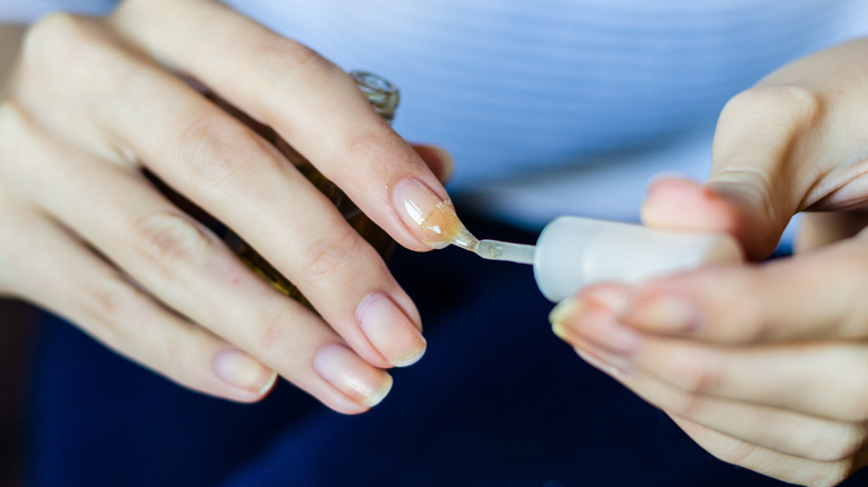woman applying clear nail base