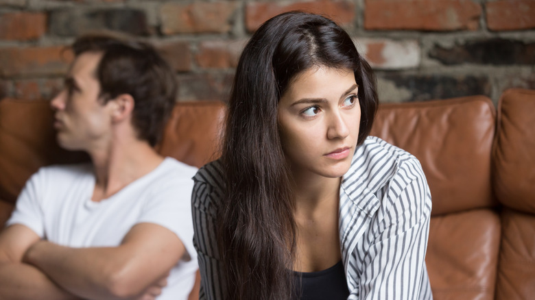 White couple sitting on sofa not speaking to each other