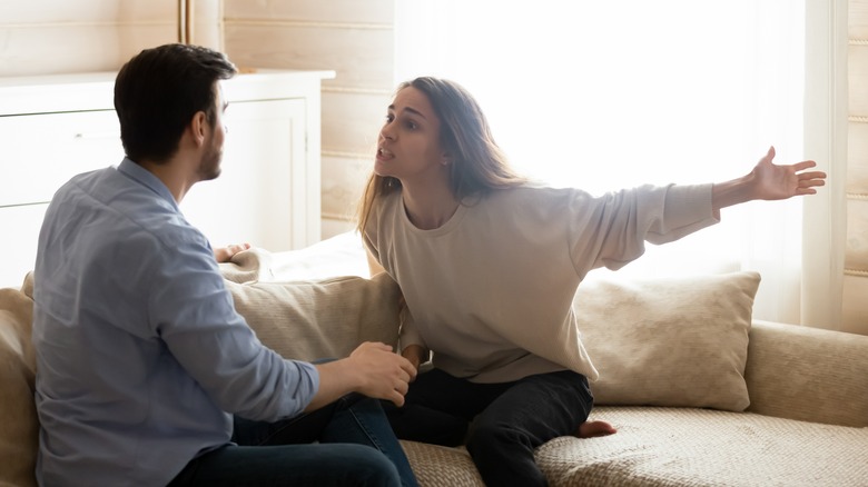 Couple sitting on sofa fighting 