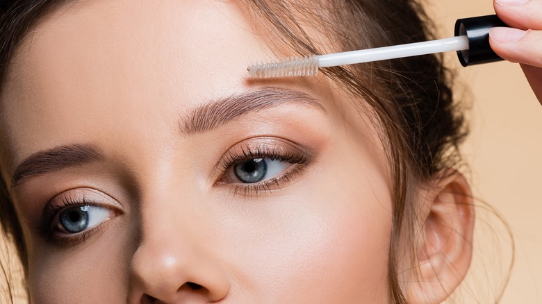 woman applying eyebrow gel