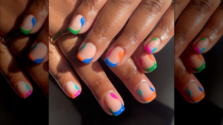 Short French manicure with colorful blobs around nail