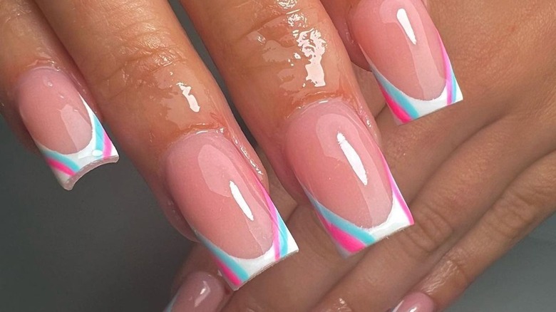 White French tip nails with pink and blue lines on sides