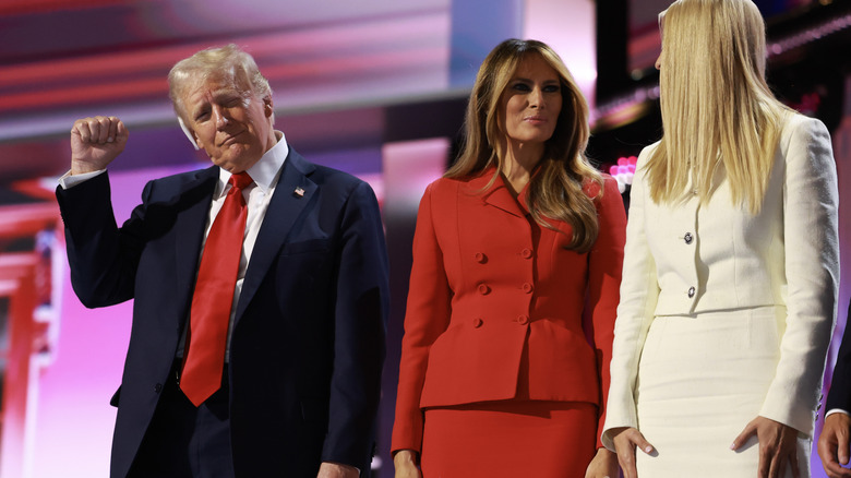 Donald Trump making victory symbol next to Melania and Ivanka Trump.