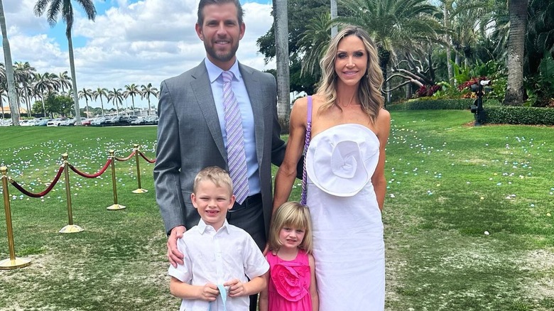 Lara Trump posing with her family while wearing a white dress with 3D detail