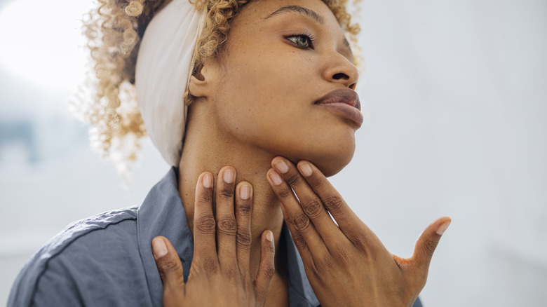 Woman touching her chin and neck 