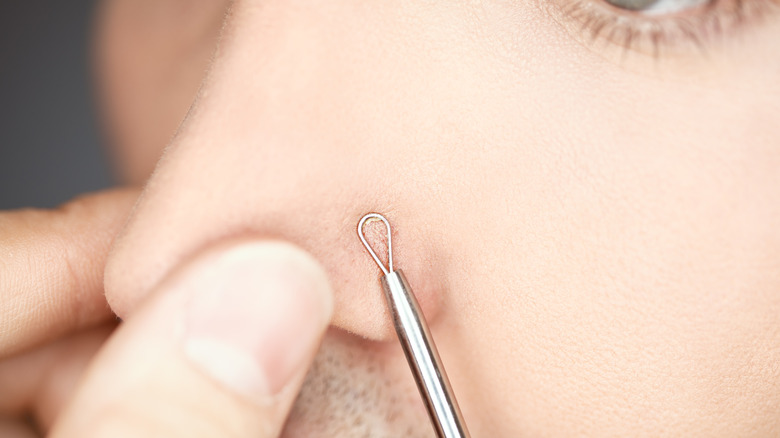 Man using extraction tool on nose 