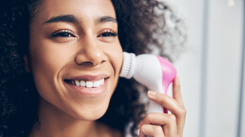 Woman exfoliates with brush