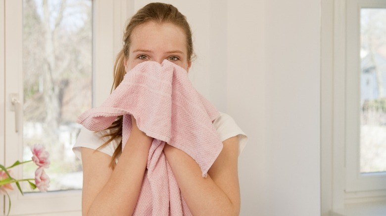 Woman drying face with towel