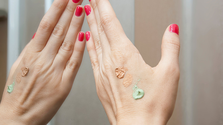 hand with different colored concealers