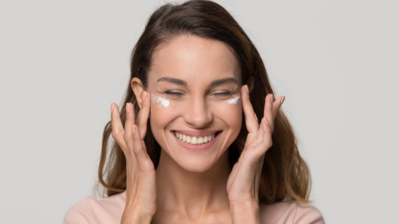 Woman putting on BB cream 