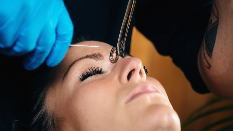 woman getting bridge piercing