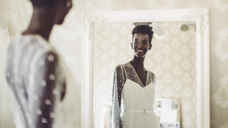 Happy bride smiling at mirror