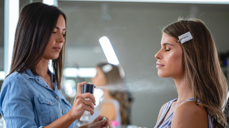 Makeup artist using setting spray 