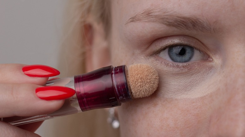 woman applying undereye concealer