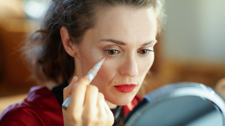 woman applying concealer