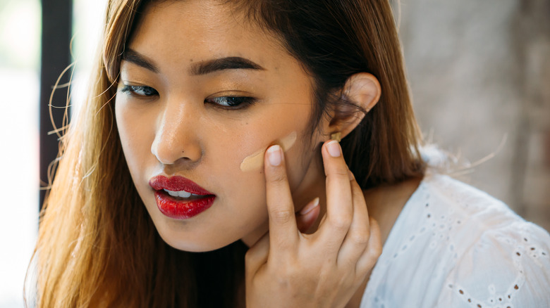 woman applying concealer