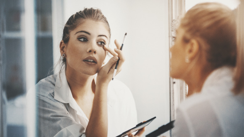 woman applying makeup