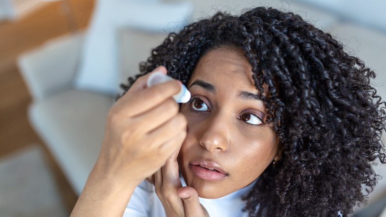 woman putting eye drops in eye