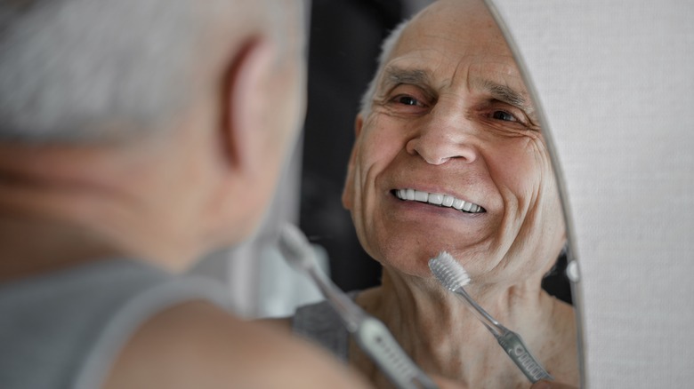 older man brushing teeth