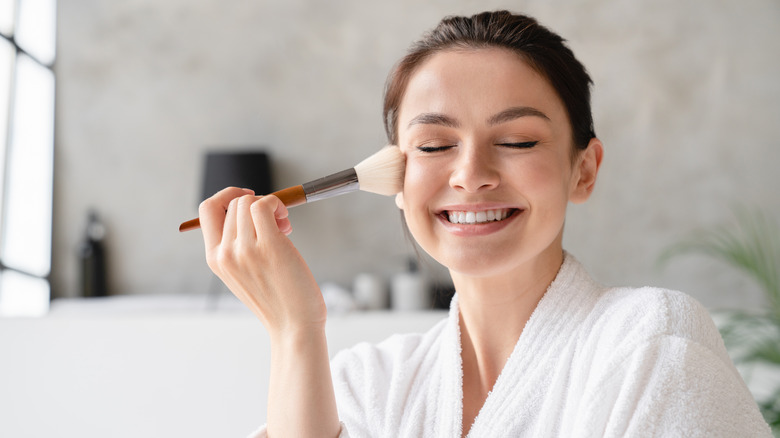 woman using blush brush