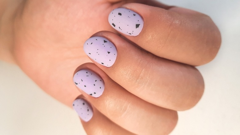 short, round lilac nails with black specks