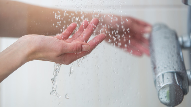 Hands feeling water temperature